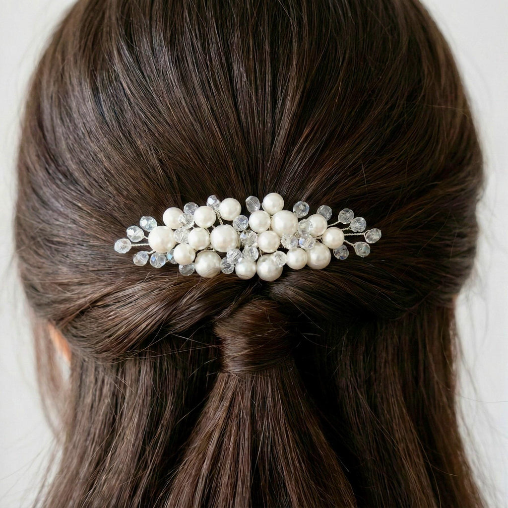 Könnte beinhalten: Haarspange mit weißen Kunstperlen und klaren Kristallen. Die Spange ist auf einer silberfarbenen Basis befestigt. Ein dekoratives Haaraccessoire für Hochzeiten oder besondere Anlässe.
