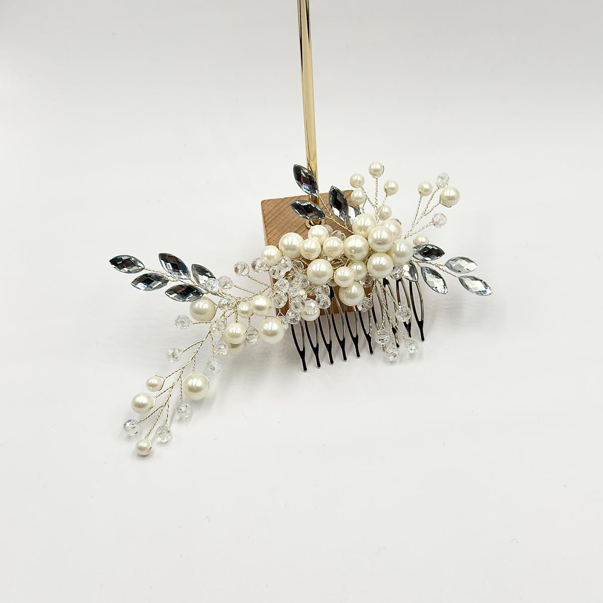 Required overhead view of the complete hair comb beside a ruler, showing its actual width, height and reach of the outer branches.